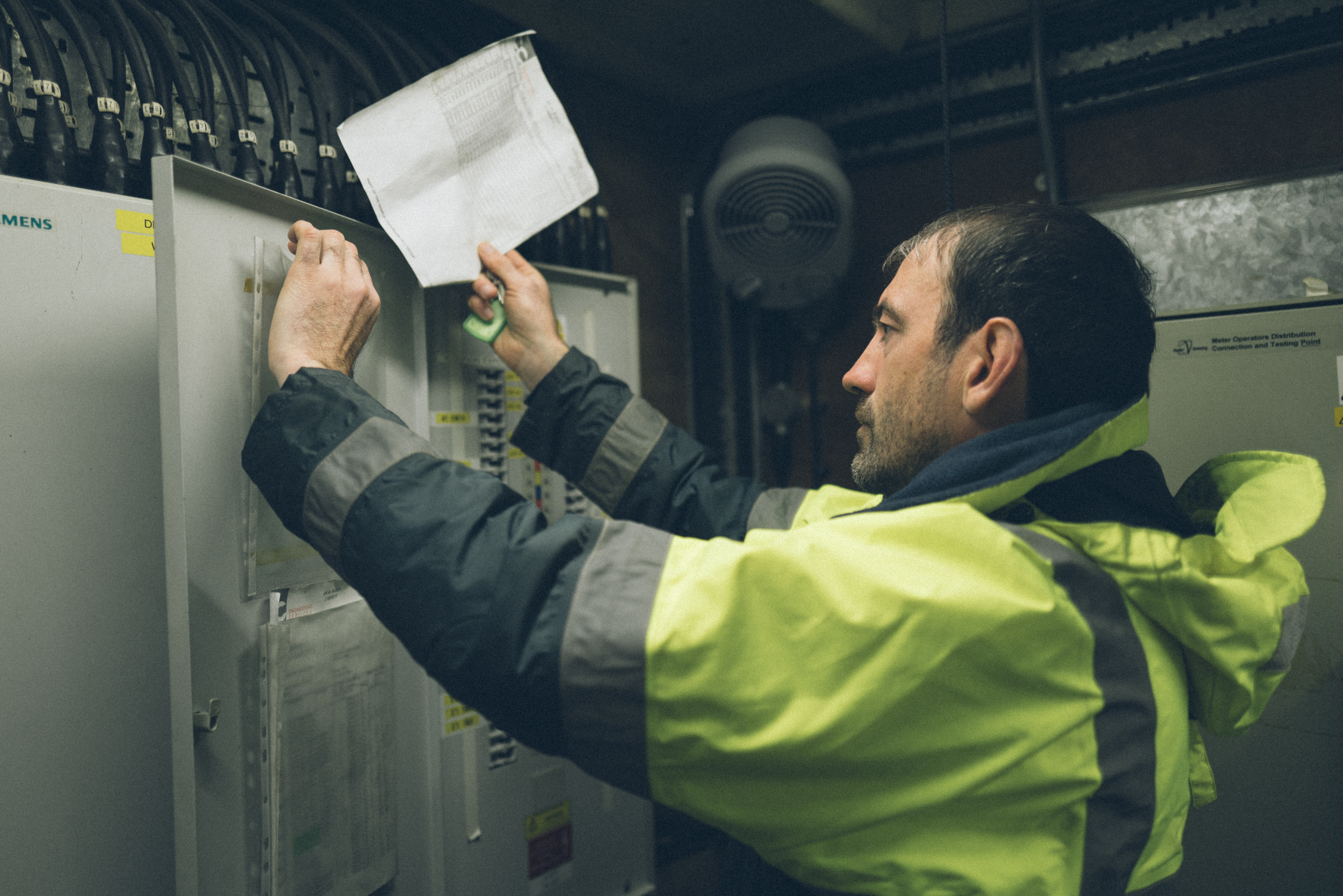 A person in hi-vis carrying out maintenance work in plant room.