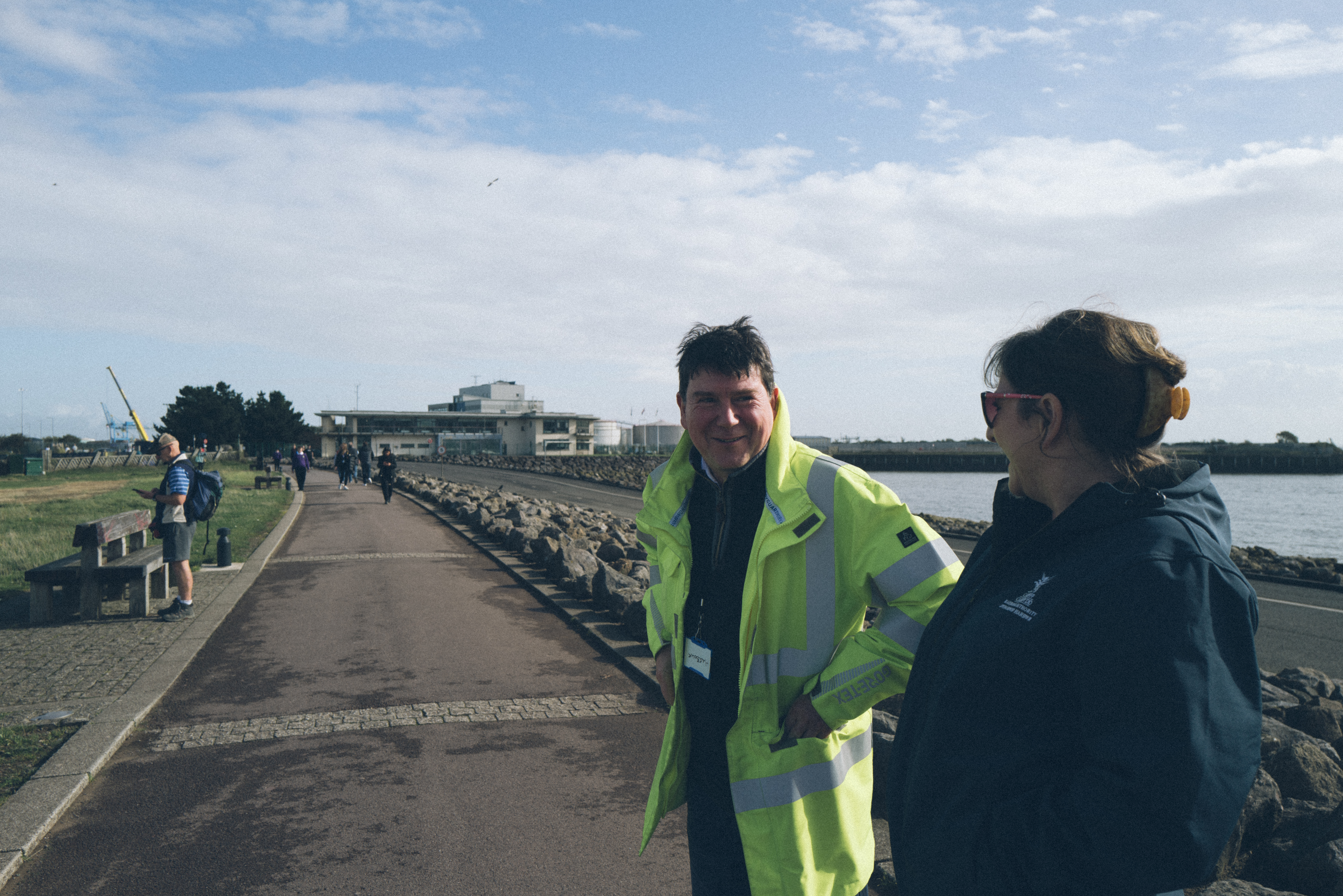 Two people on the barrage talking, One in hi-vis jacket.