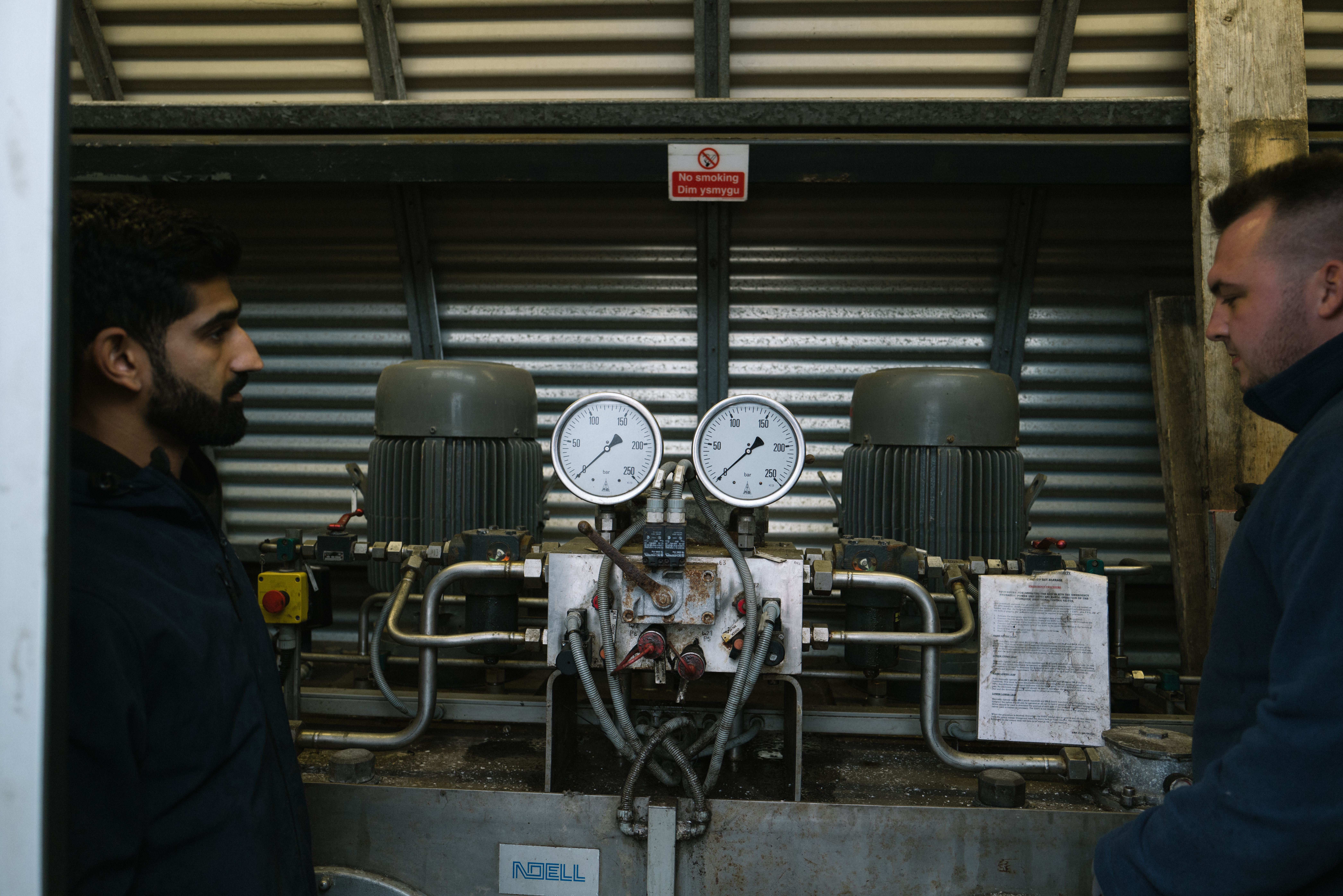 Two people inspecting a machine.